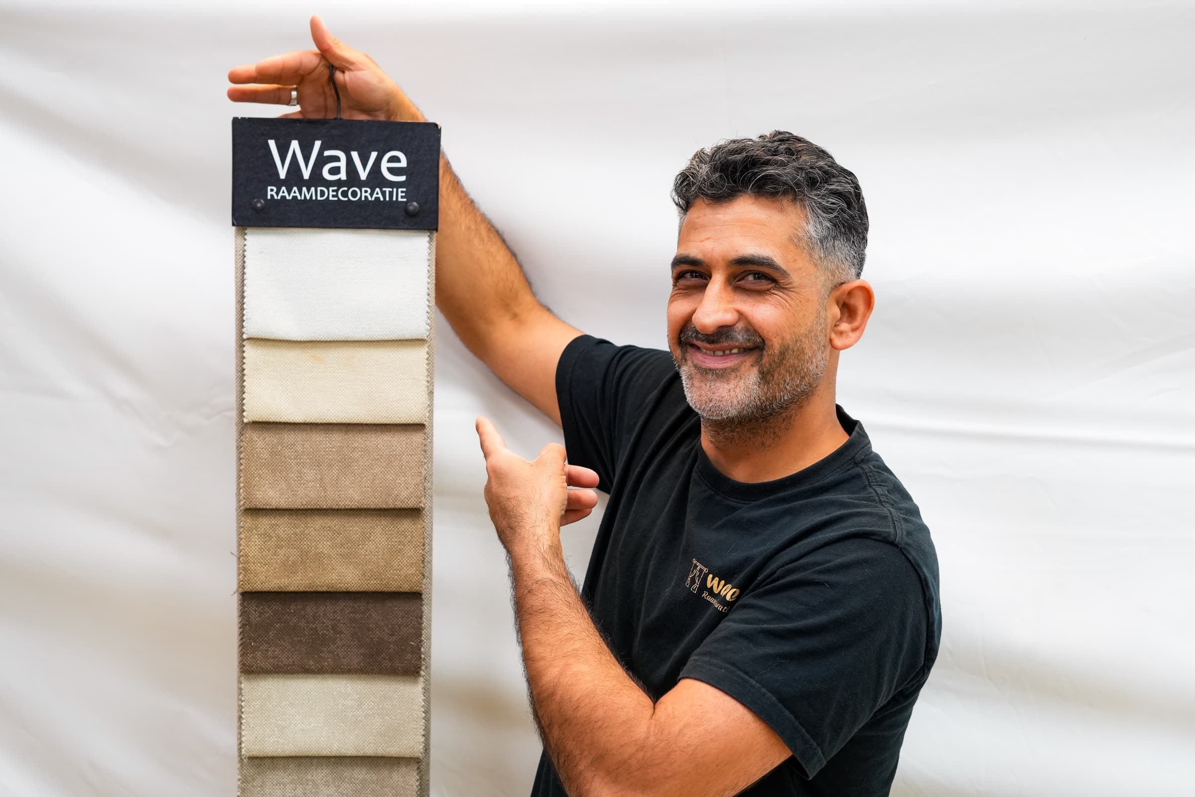 Masoud bij stofstalen in de Wave-winkel